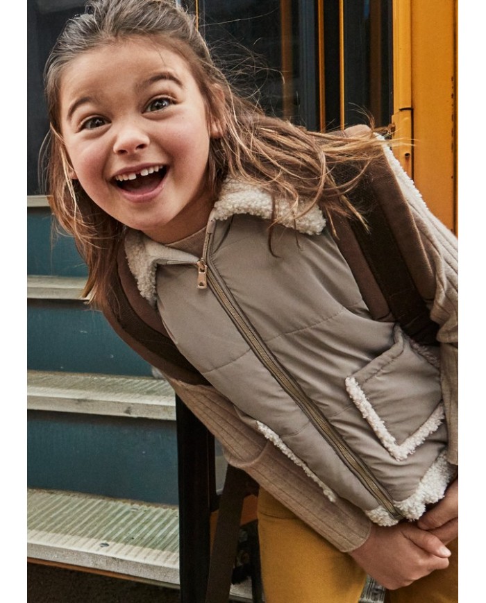 Bernumode | Mayoral: Vest for girl €34.63 Vest from the Mayoral collection.This mid-season model is made from a soft and pleasant-to-the-touch material.


Simple design that does not restrict movement.


Convenient zipper makes it easy to put on and take off.


Two patch side pockets.


Fleece lining.


Model with a collar.


Girls’ padded vest made with recycled polyester. Features a faux fur collar and a front zip fastening. Quilted textile exterior with a cozy touch. The inner lining is partly made of soft sherpa for extra warmth and comfort. Functional front pockets complete the design.