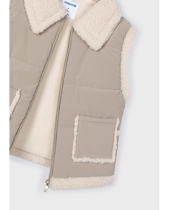 Bernumode | Mayoral: Vest for girl €34.63 Vest from the Mayoral collection.This mid-season model is made from a soft and pleasant-to-the-touch material.


Simple design that does not restrict movement.


Convenient zipper makes it easy to put on and take off.


Two patch side pockets.


Fleece lining.


Model with a collar.


Girls’ padded vest made with recycled polyester. Features a faux fur collar and a front zip fastening. Quilted textile exterior with a cozy touch. The inner lining is partly made of soft sherpa for extra warmth and comfort. Functional front pockets complete the design.